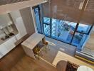 Modern kitchen with island and two stools, natural light through large windows