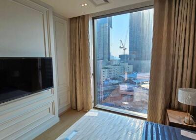 Bedroom with large window view of cityscape and mounted TV