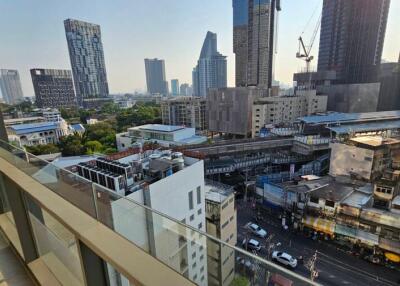 View from balcony overlooking cityscape with modern buildings and construction crane