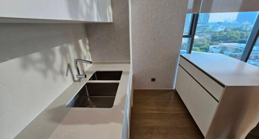 Modern kitchen with dual sinks and a city view.