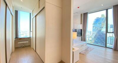 Spacious bedroom with large windows offering a city view and ample storage space.