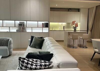 Modern open plan living room and kitchen with white furniture and wooden flooring