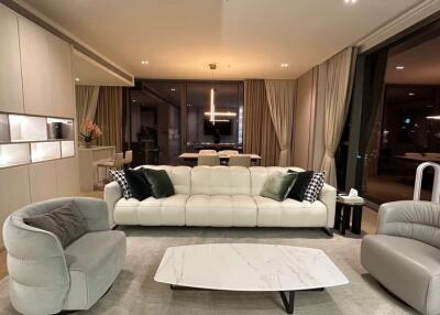 Modern living room with a beige sofa, cozy armchairs, and a minimalist coffee table.