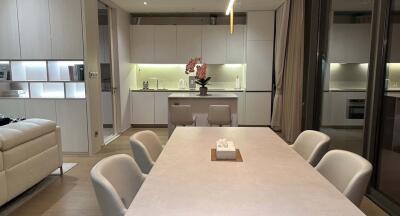 Modern open-concept kitchen and dining area with white cabinetry and pendant lighting