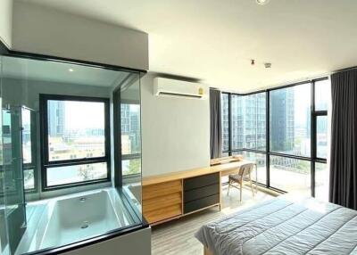 Bright modern bedroom with large windows and a built-in bathtub