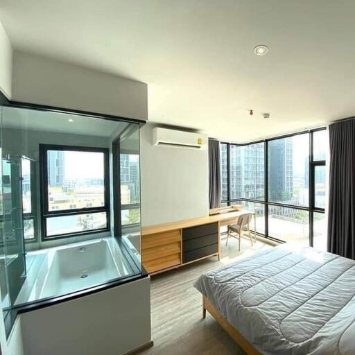 Bright modern bedroom with large windows and a built-in bathtub