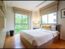 Spacious bedroom with large windows and a double bed