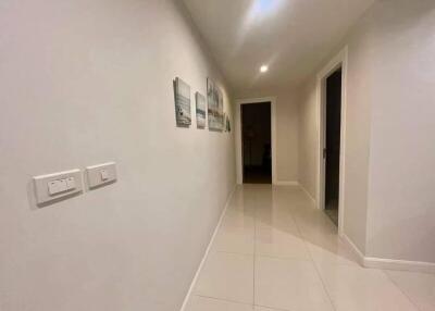 well-lit hallway with tiled floor and framed pictures