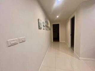 well-lit hallway with tiled floor and framed pictures