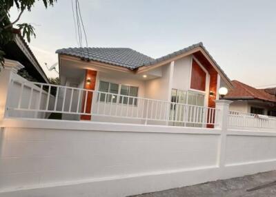 Exterior view of a single-story house with a fenced yard