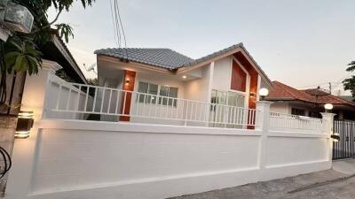 Exterior view of a single-story house with a fenced yard