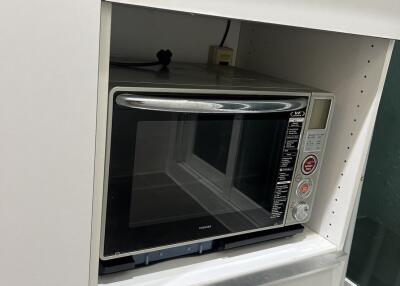 Built-in kitchen microwave oven with surrounding storage