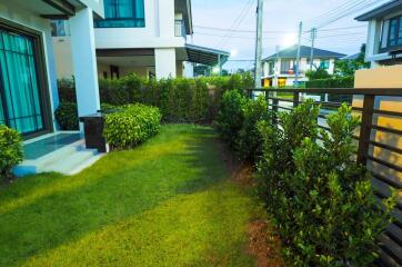 View of house exterior with lawn and garden