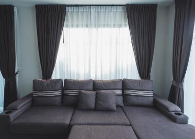 Contemporary living room with a dark grey sofa and curtains