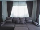 Contemporary living room with a dark grey sofa and curtains