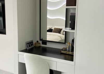Vanity area with a mirror and chair in modern bedroom