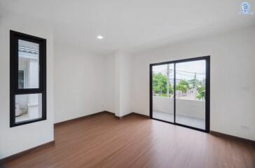 Spacious living room with wooden flooring and large windows