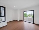 Spacious living room with wooden flooring and large windows