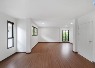 Spacious, unfurnished living area with wooden floors and large windows