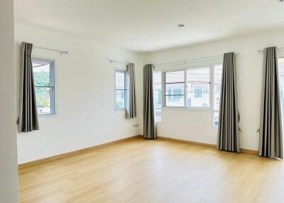 Spacious and bright main living area with large windows and hardwood flooring