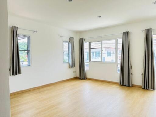 Spacious and bright main living area with large windows and hardwood flooring