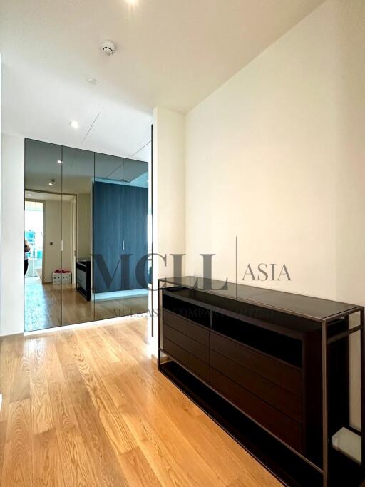 Spacious bedroom with wooden floor and built-in mirrored wardrobe