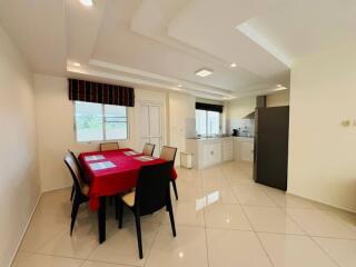 Dining area with a red tablecloth and a view of the kitchen