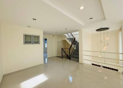 Spacious living area with modern lighting and staircase
