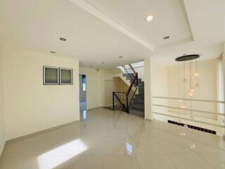 Spacious living area with modern lighting and staircase