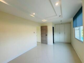 Spacious bedroom with large wardrobe and natural lighting