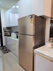 Modern kitchen with stainless steel refrigerator and white cabinetry