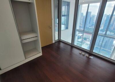 Bedroom with wooden flooring and large windows with city view