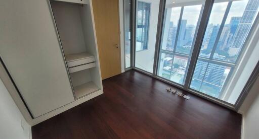 Unfurnished bedroom with large windows and city view