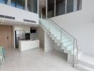 Modern duplex living space with staircase and kitchen area
