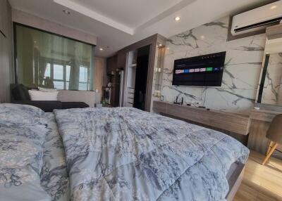 Modern bedroom with bed, TV, and air conditioning