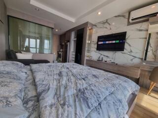 Modern bedroom with bed, TV, and air conditioning