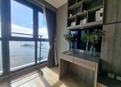 Bedroom with desk, large window, and water view