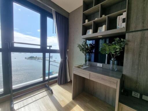 Bedroom with desk, large window, and water view