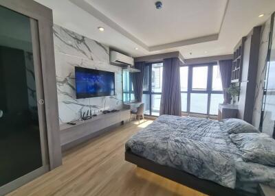 Modern bedroom with large windows and TV