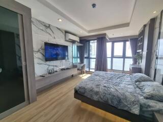 Modern bedroom with large windows and TV