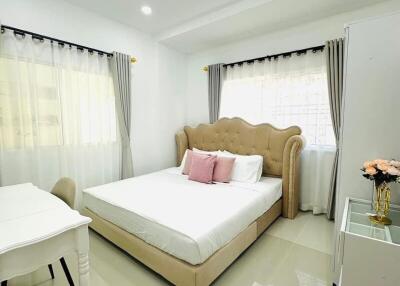 Bedroom with beige bed and white decor