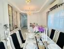 Elegant dining area with modern table setting, chandelier lighting, and large windows.