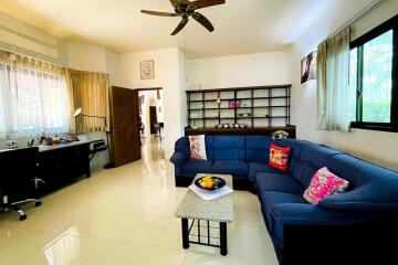 Spacious living room with sectional sofa, desk, and bookshelf