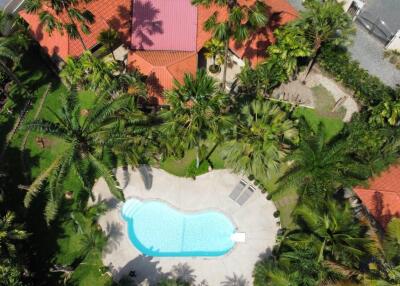 Aerial view of a property with a swimming pool and lush landscaping