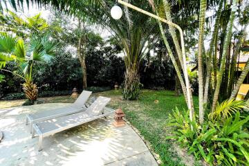 Outdoor patio with lounge chairs and greenery