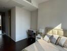 Well-lit modern bedroom with a bed, pillows, bedside table, lamp, and a small desk next to the window.