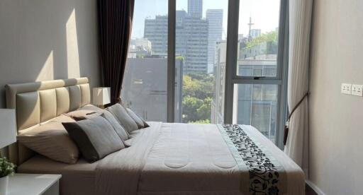 Modern bedroom with a large window view of cityscape