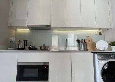 Modern kitchen with appliances including microwave and washing machine