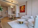 Modern living room with a minimalist design featuring a white sofa, coffee table, wall art, and dining area