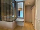 Bedroom area with modern design featuring large windows, a small vanity, and sliding closet doors